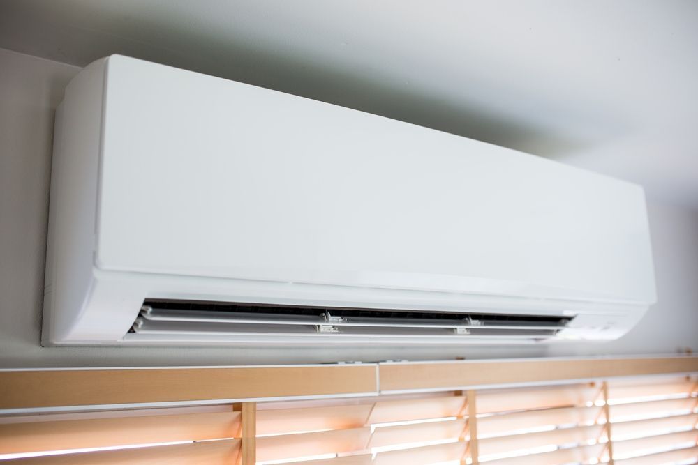 White Wall-mounted Air Conditioner Above Wooden Blinds — Mackies In Forster, NSW