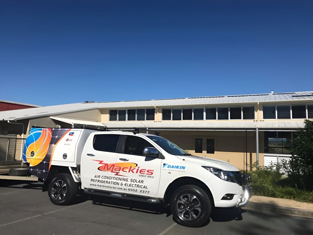 White Mackies Service Truck Parked In Front Of A Low-rise Building — Mackies in Coffs Harbour, NSW
