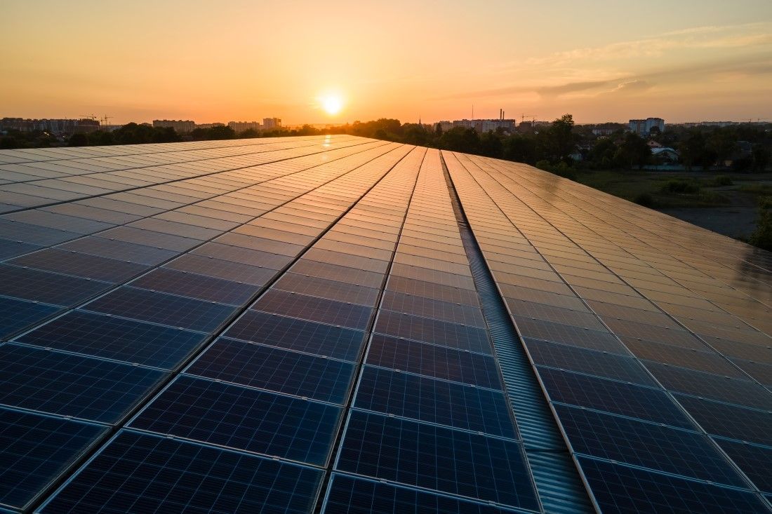 Solar Panels On A Rooftop Reflecting The Orange Glow Of A Sunset — Mackies In Coffs Harbour, NSW