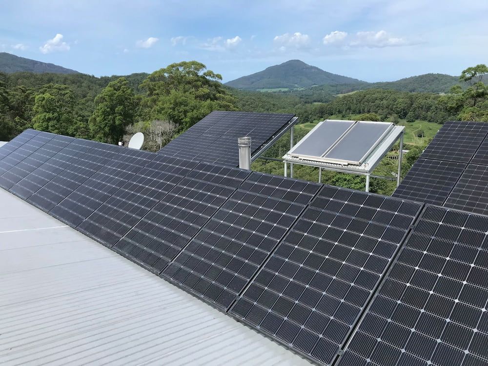 A Row Of Solar Panels On A Roof With Mountains In The Background — Mackies In Taree, NSW