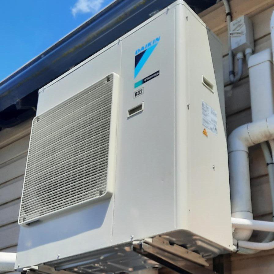 Daikin Air Conditioner Unit Mounted Outdoors On A Building Wall — Mackies in Taree, NSW