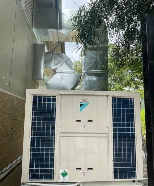 A Large Air Conditioner Is Sitting On The Side Of A Building — Mackies In Taree, NSW