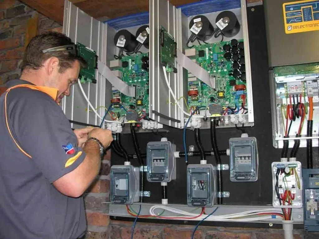 A Man Is Working On An Electrical Box With A Sticker On It That Says 'Electrical' — Mackies In Taree, NSW