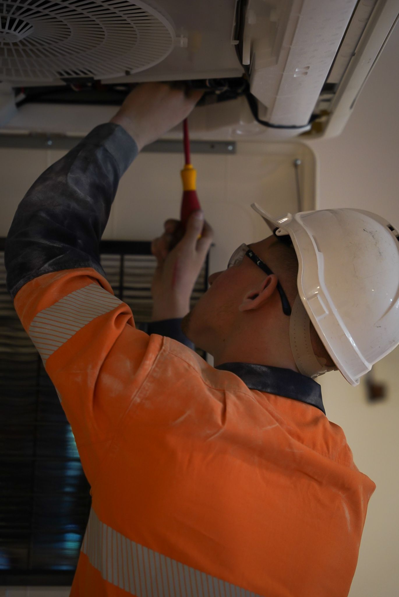 A Worker In An Orange Vest And White Hard Hat — Mackies in Taree, NSW