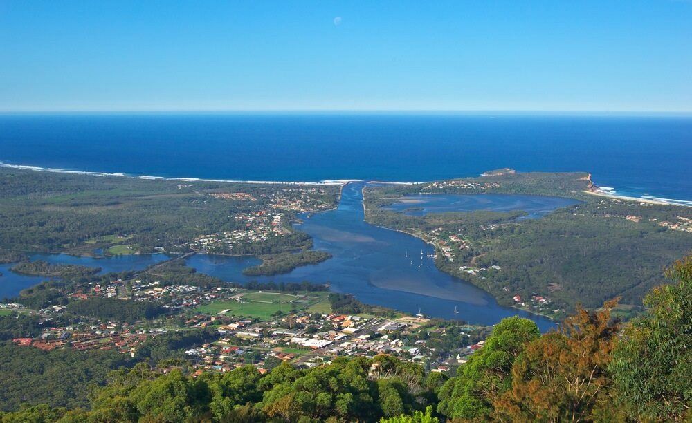 An Aerial View Of A River Surrounded By Trees And A Body Of Water — Mackies In Laurieton, NSW