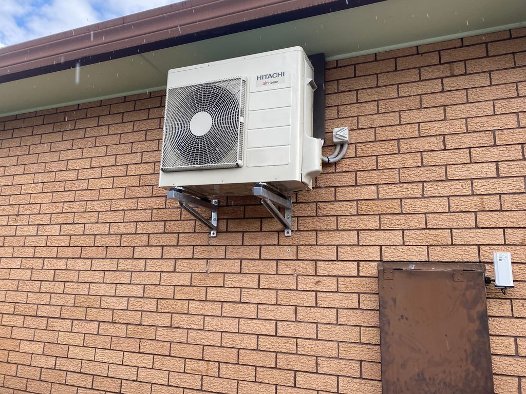 Air Conditioning Unit Mounted On A Brick Wall, Supported By Metal Brackets — Mackies in Taree, NSW