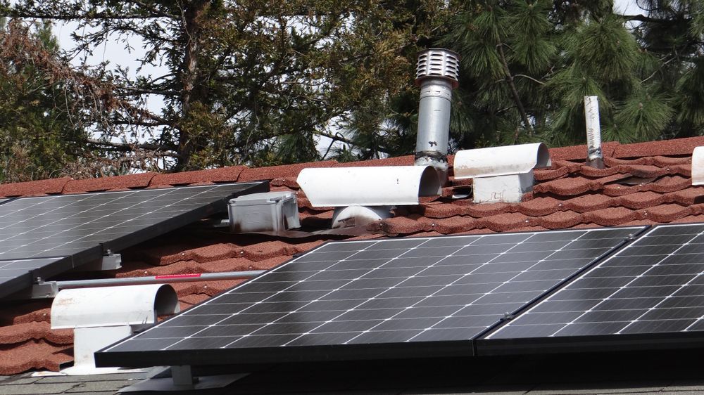 Rooftop With Red Shingles Featuring Solar Panels