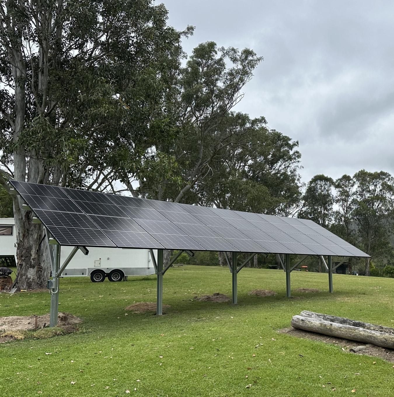 Solar Panels Mounted On A Metal Frame In A Grassy Field — Mackies in Taree, NSW