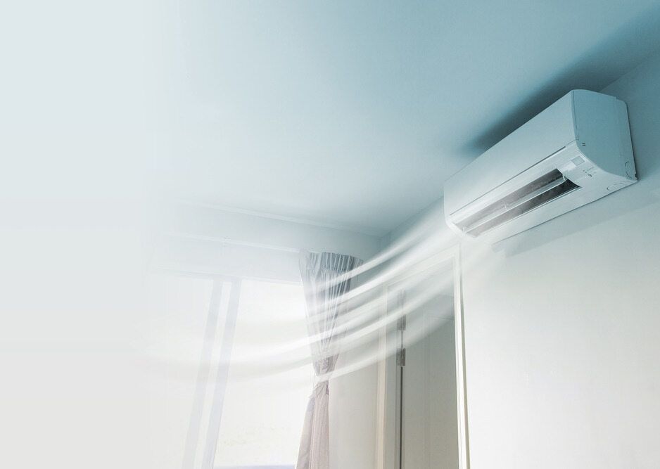 White Air Conditioning Unit Mounted On A Ceiling Blowing Cool Air Into A Room — Mackies in Taree, NSW