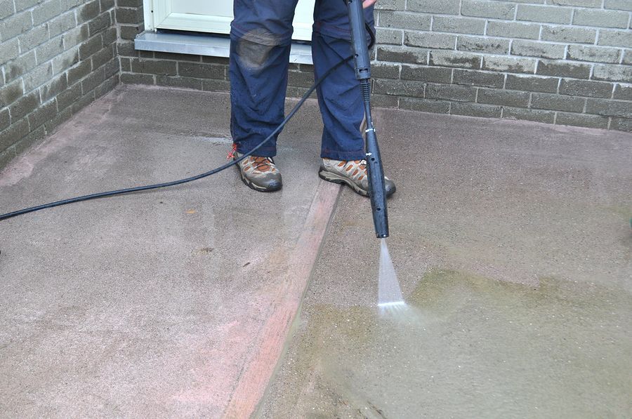 a man using a pressure washer on concrete