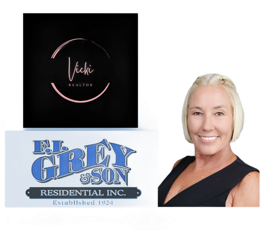 Person working at a light wood desk with a laptop. Desk has books and a vase with eucalyptus.