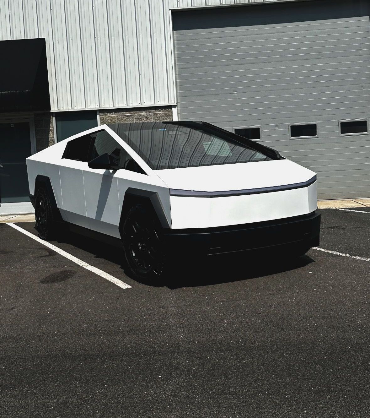 A person wearing black gloves is touching a tire