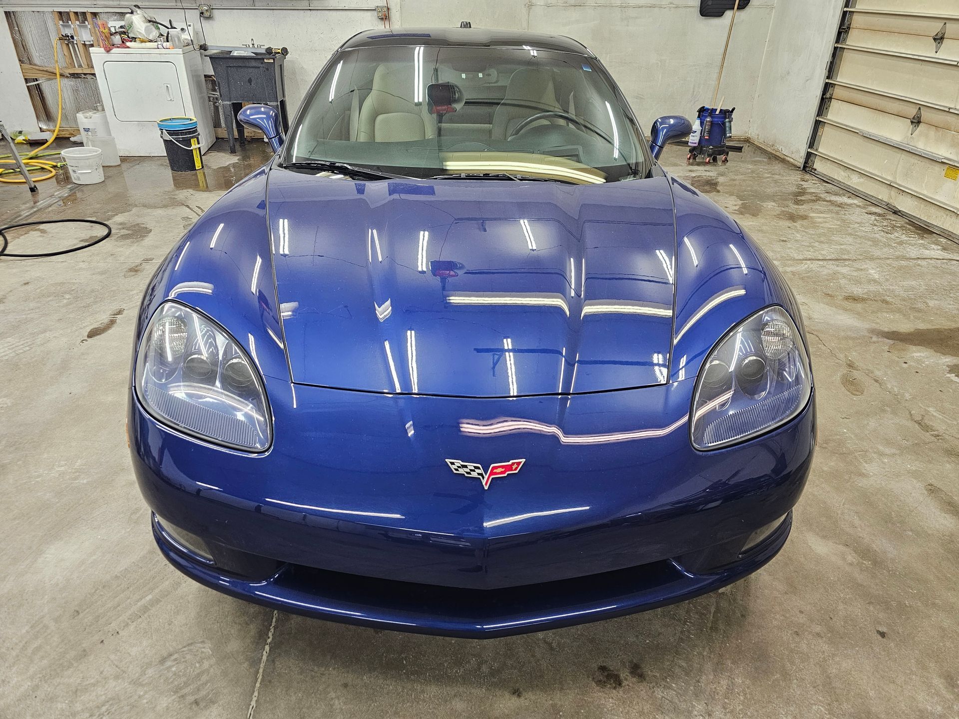 A blue sports car is parked in a garage.