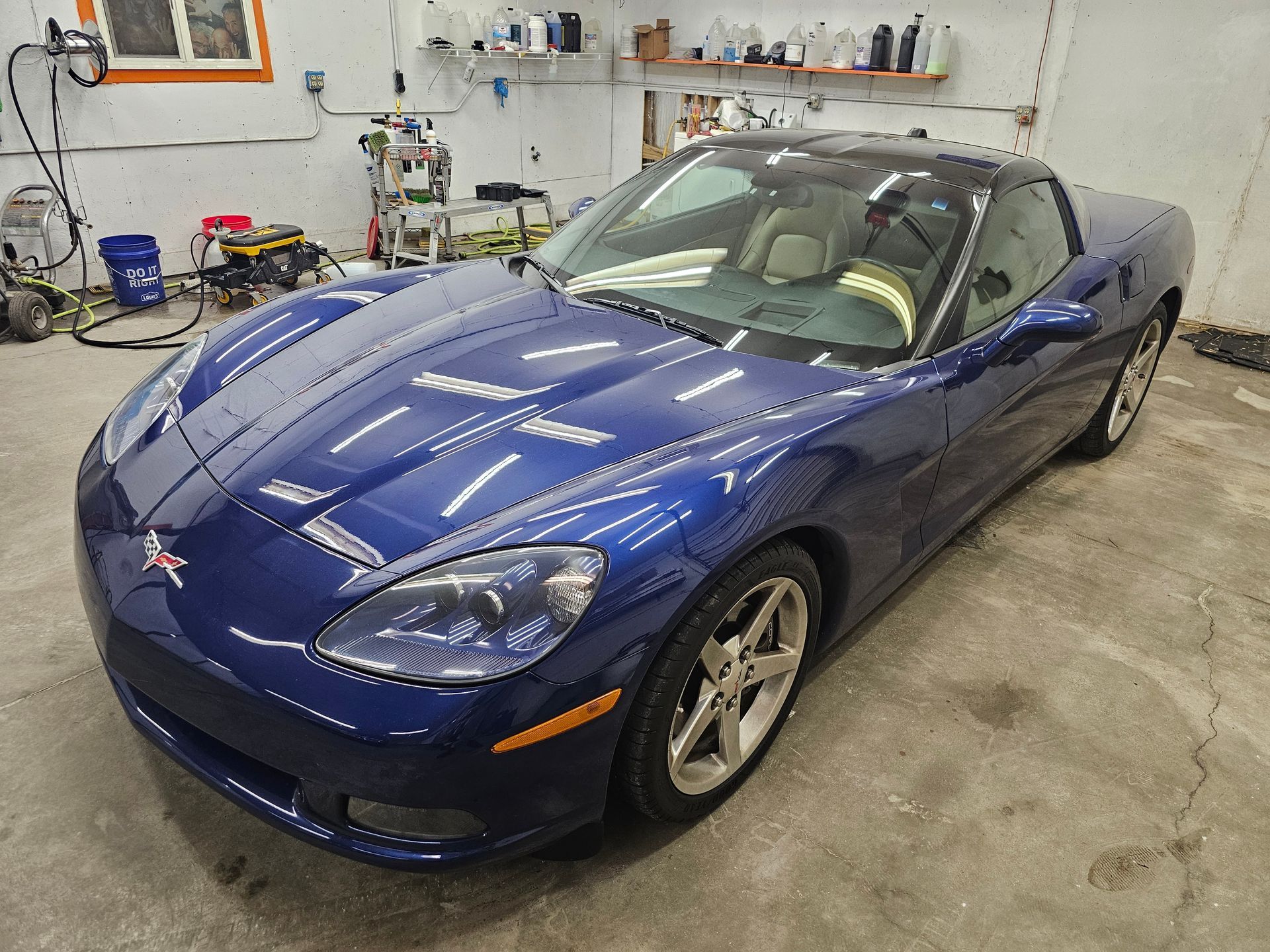 A blue corvette is parked in a garage.