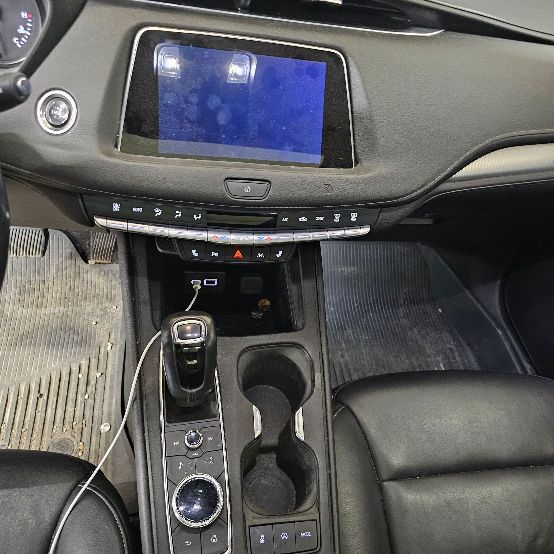 The dashboard of a car with a phone plugged into it