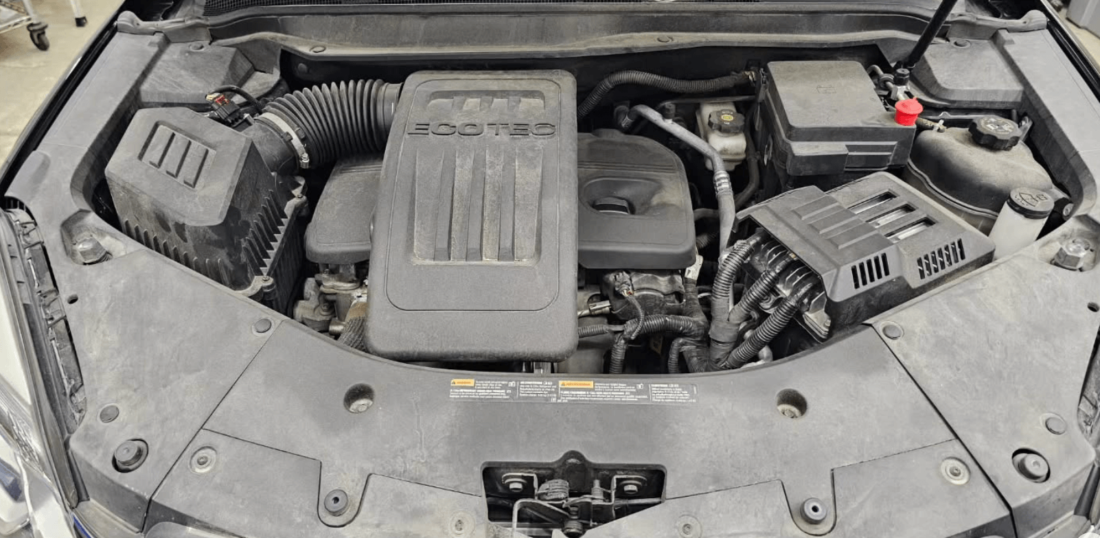 The engine of a car is shown with the hood open.