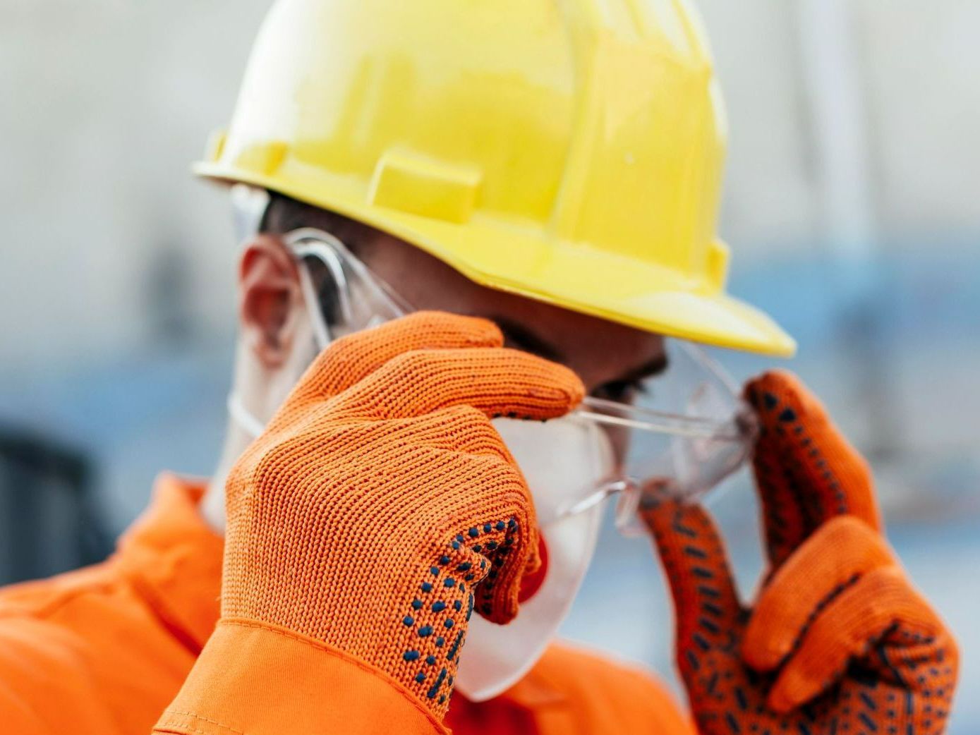 A construction worker wearing a hard hat and safety glasses.
