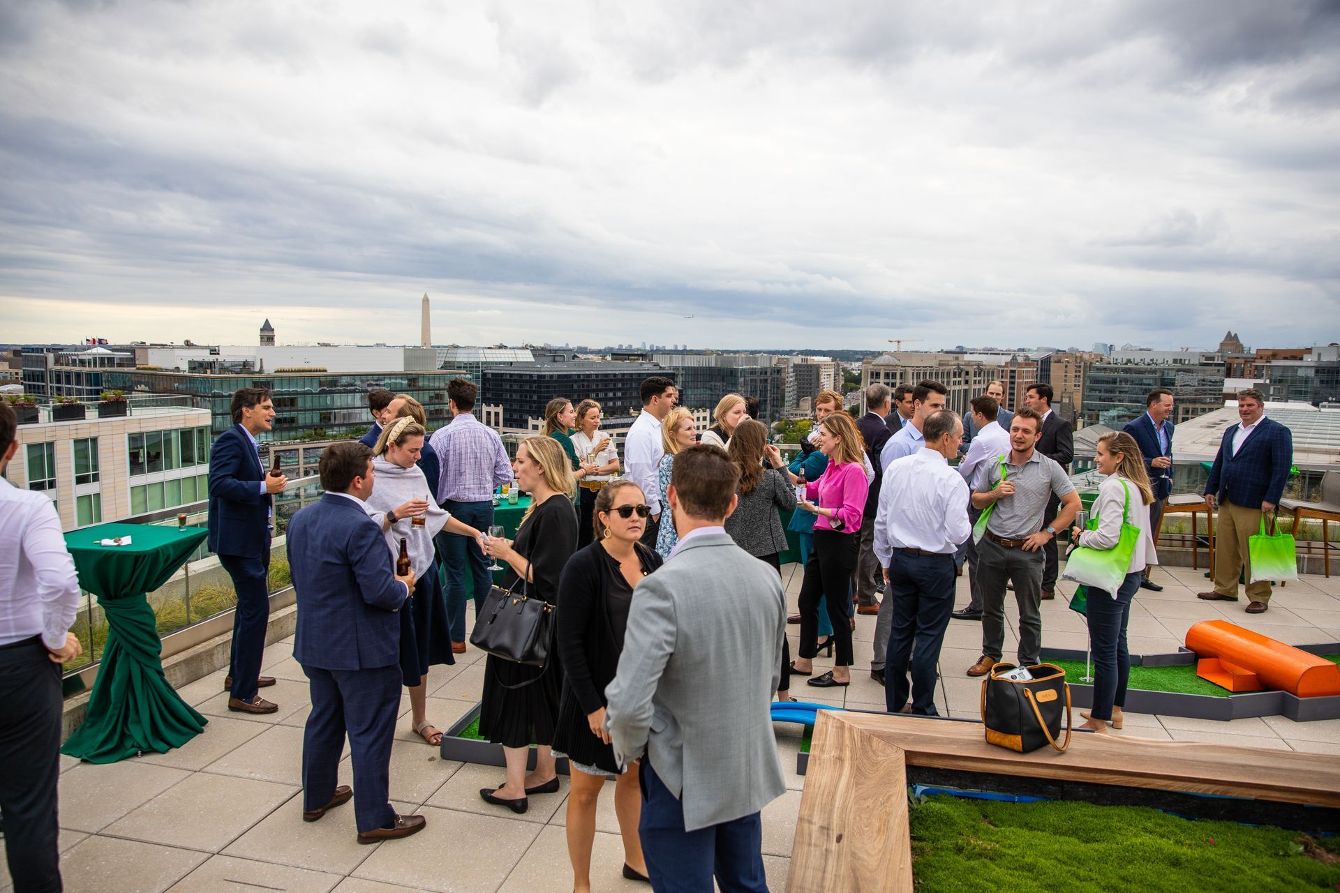 A group of people are standing on a rooftop talking to each other.