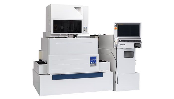 A white machine with a computer on top of it.