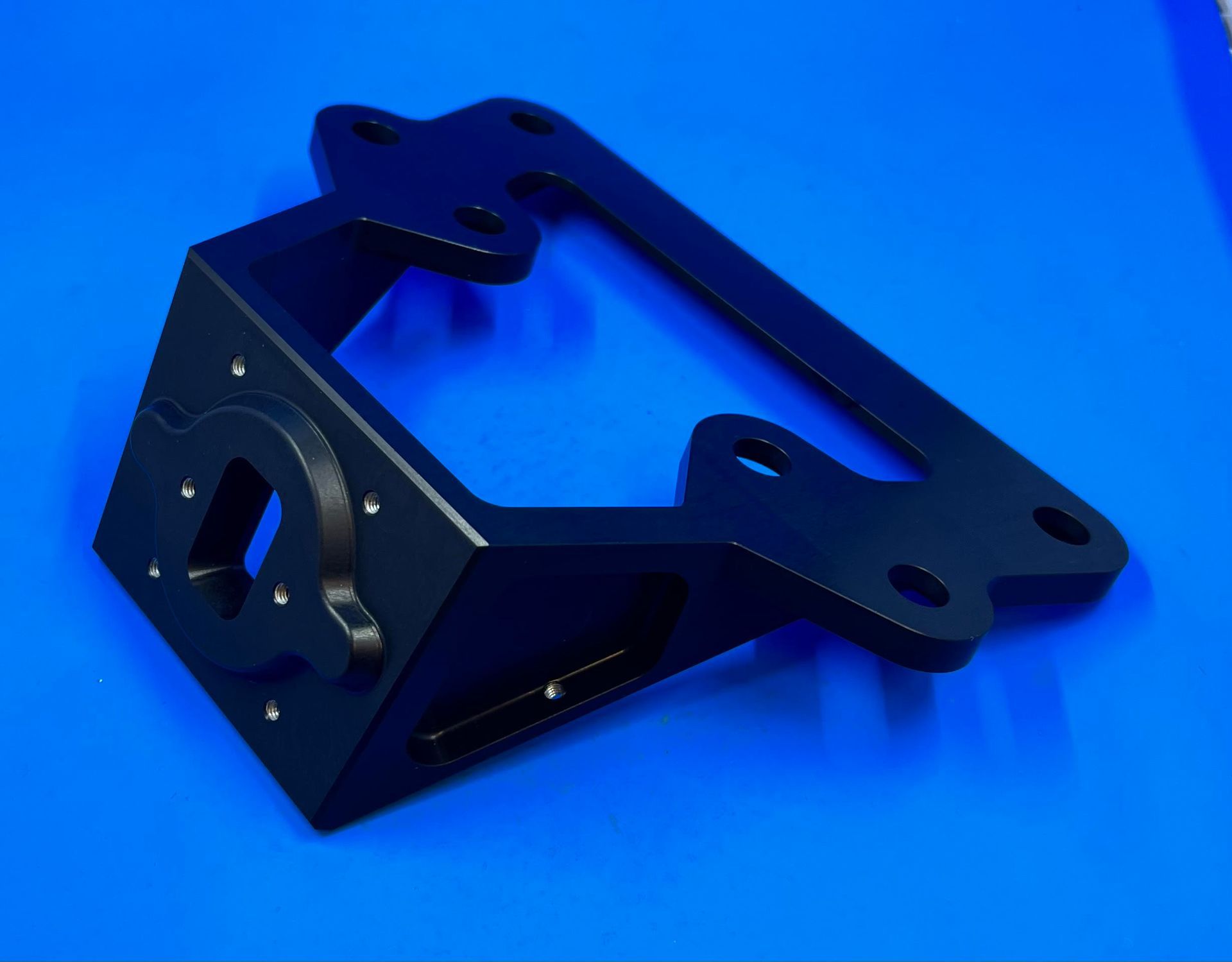 A black metal bracket is sitting on a blue surface