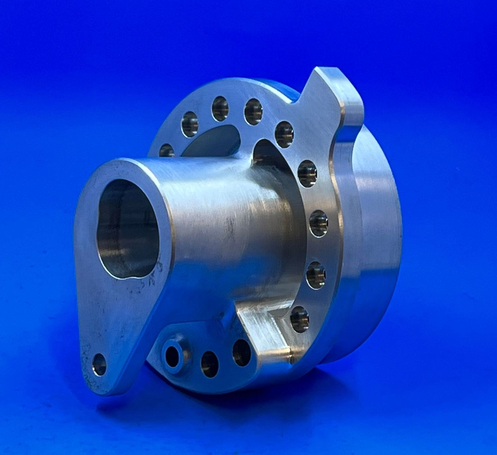 A piece of metal with holes in it is on a blue surface