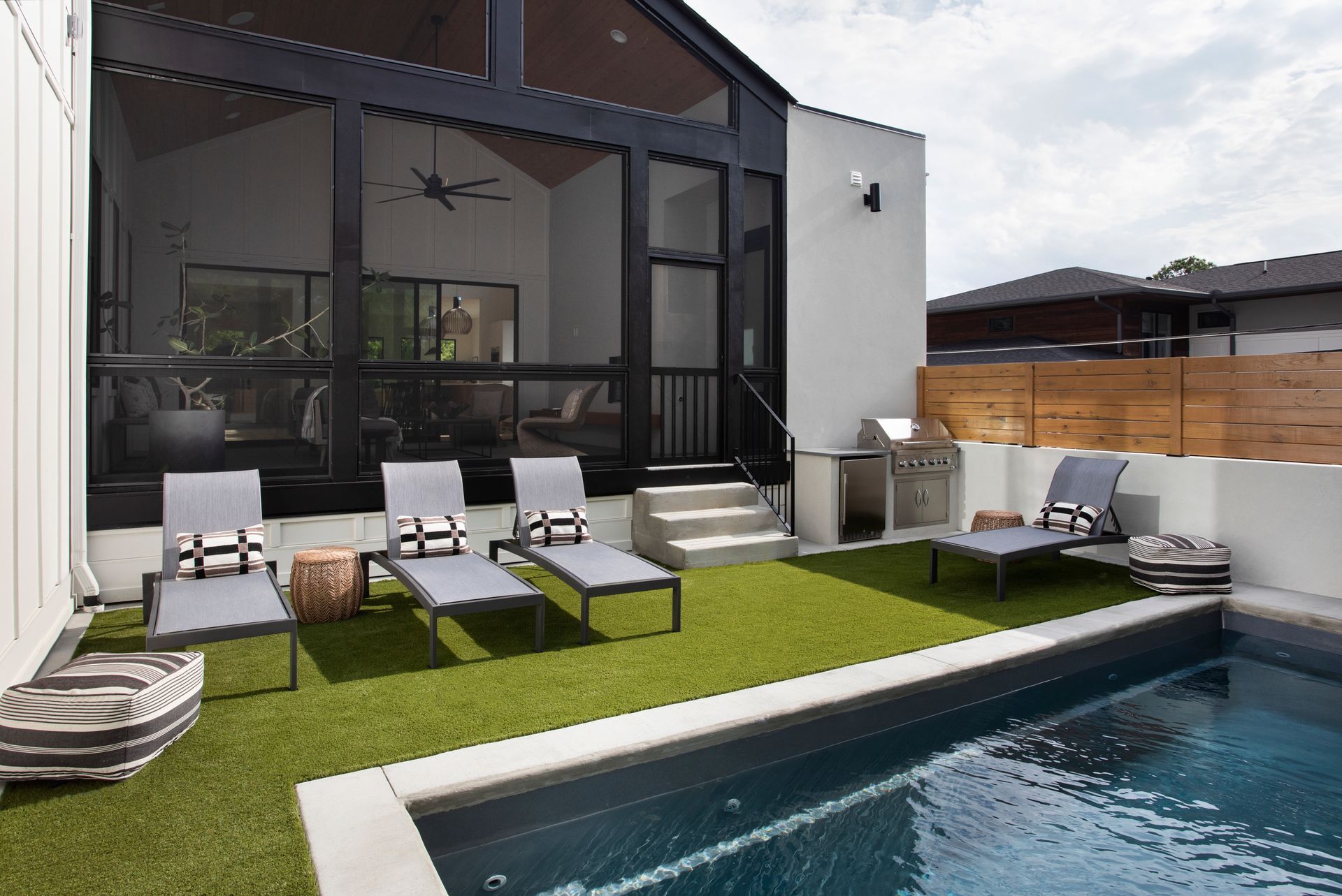 There is a swimming pool in the backyard of a house.