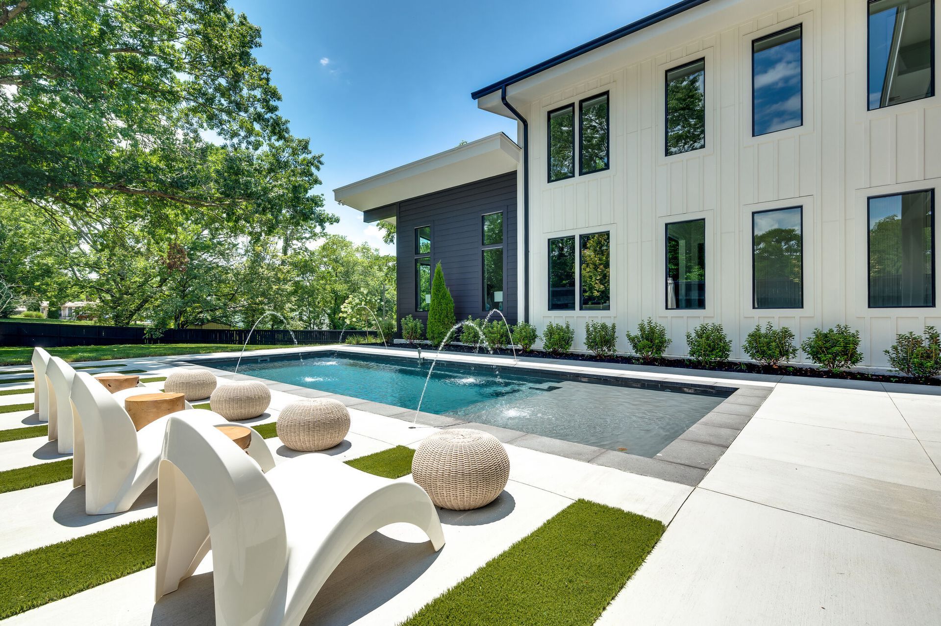 A large white house with a large swimming pool in front of it