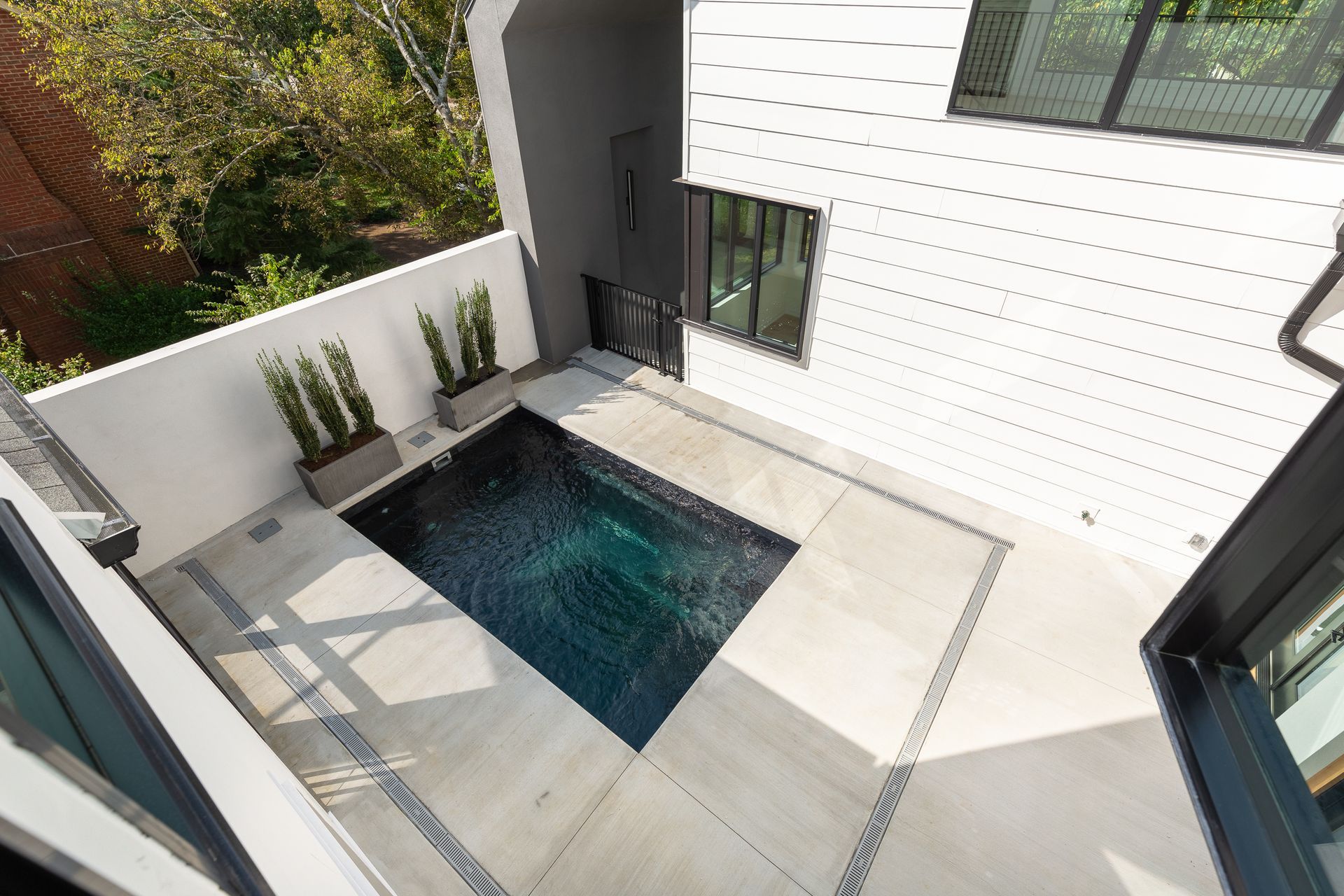 An aerial view of a swimming pool in the backyard of a house