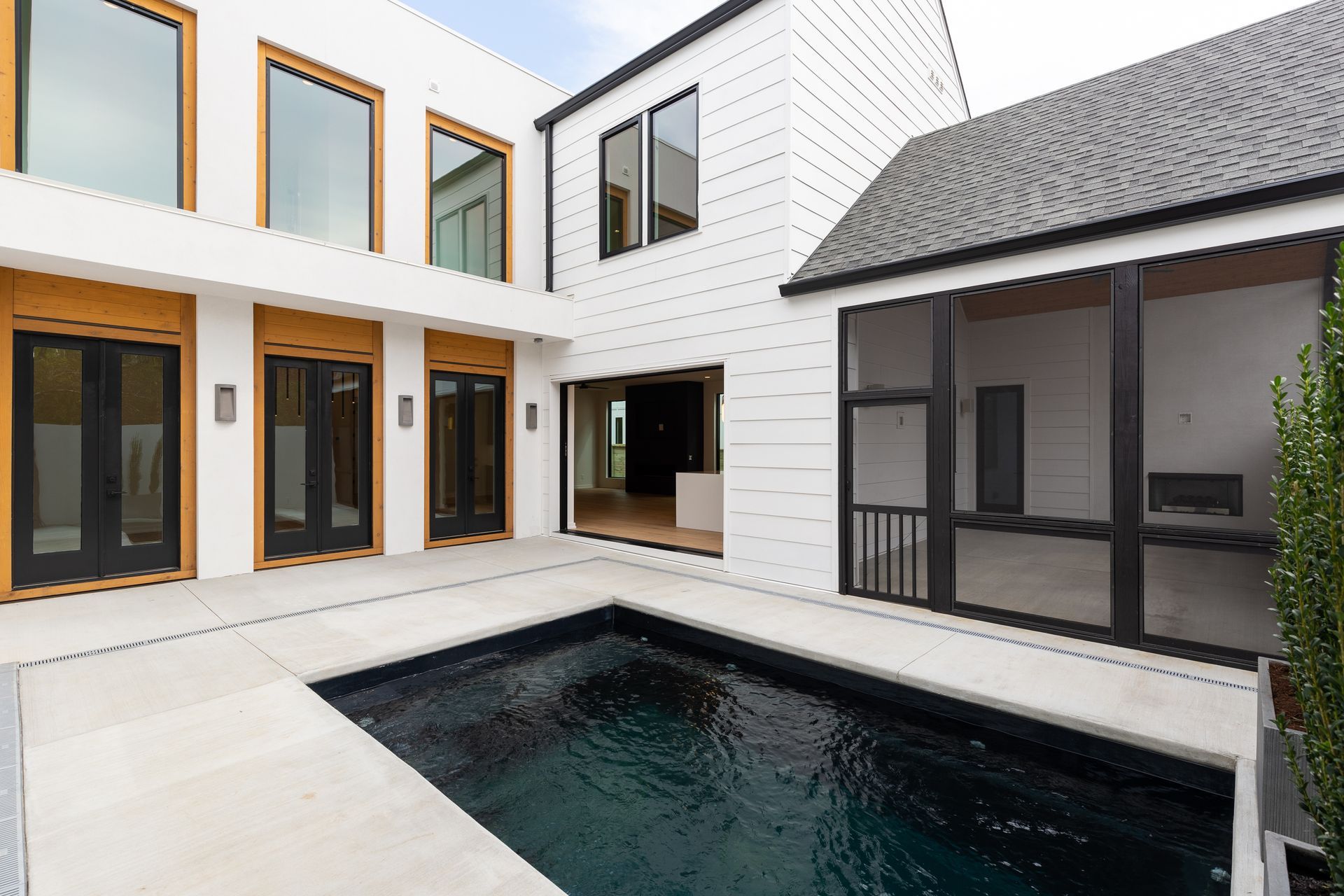 A large white house with a swimming pool in the middle of it.