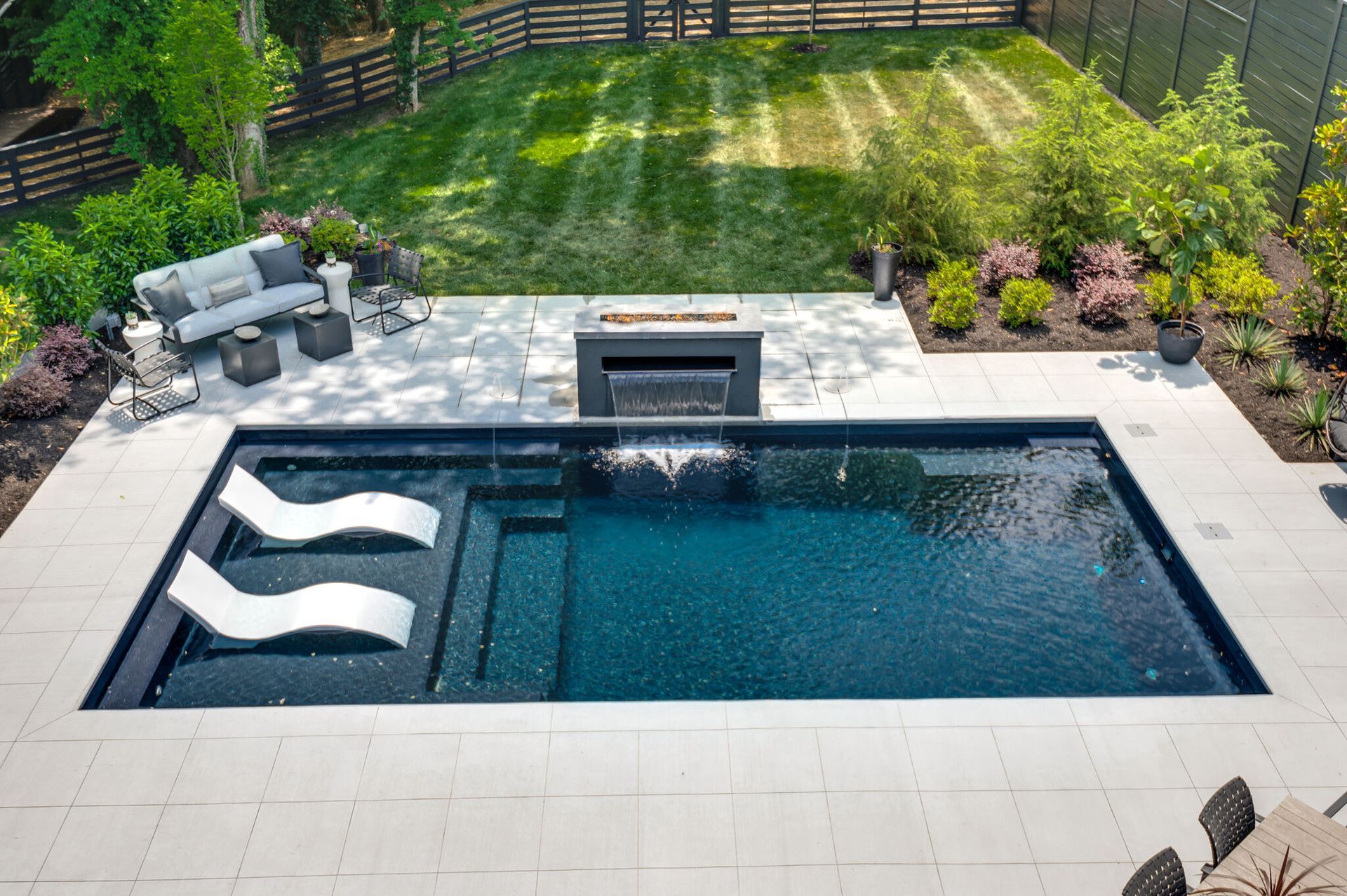 An aerial view of a large swimming pool in a backyard.