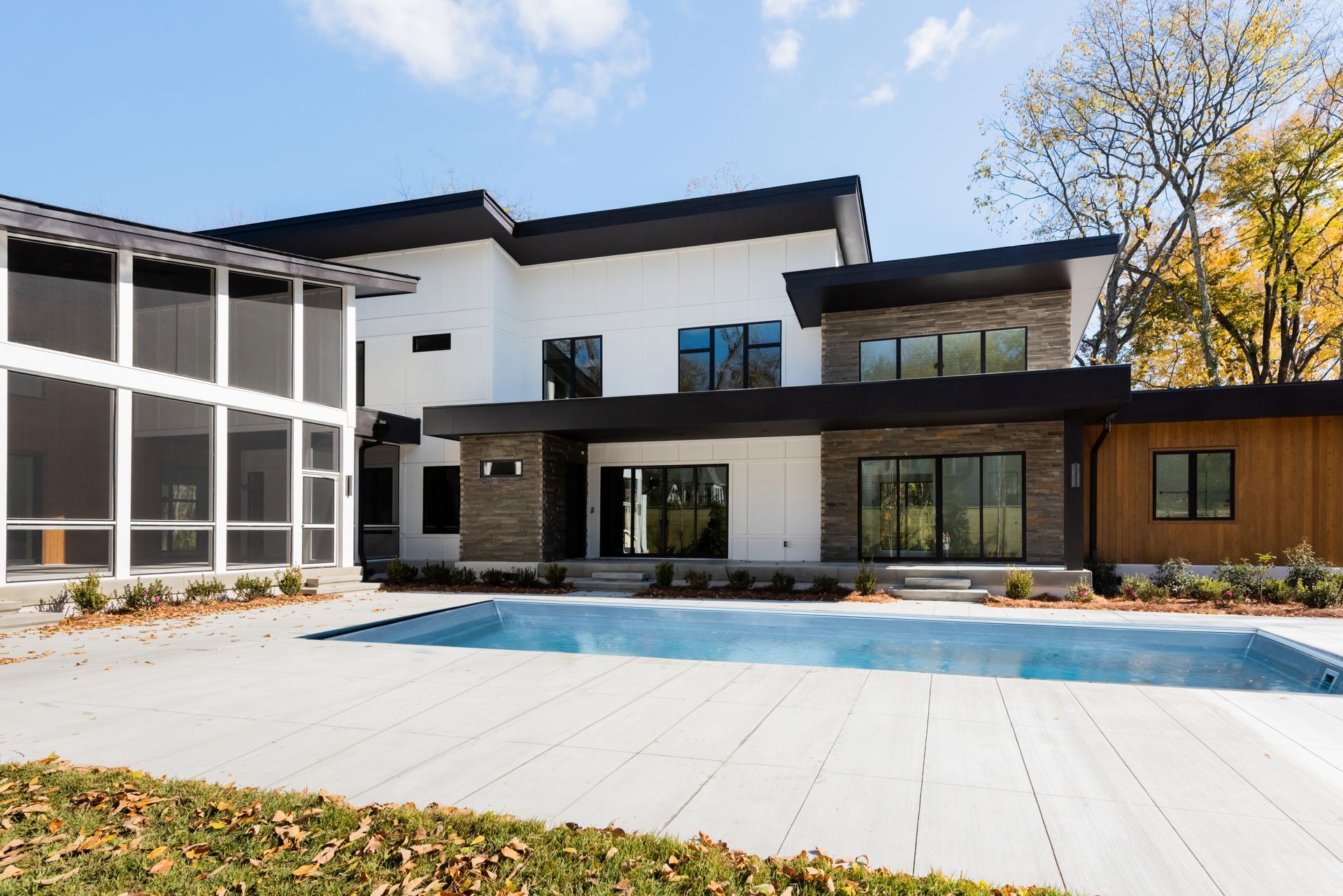 A large house with a swimming pool in front of it.