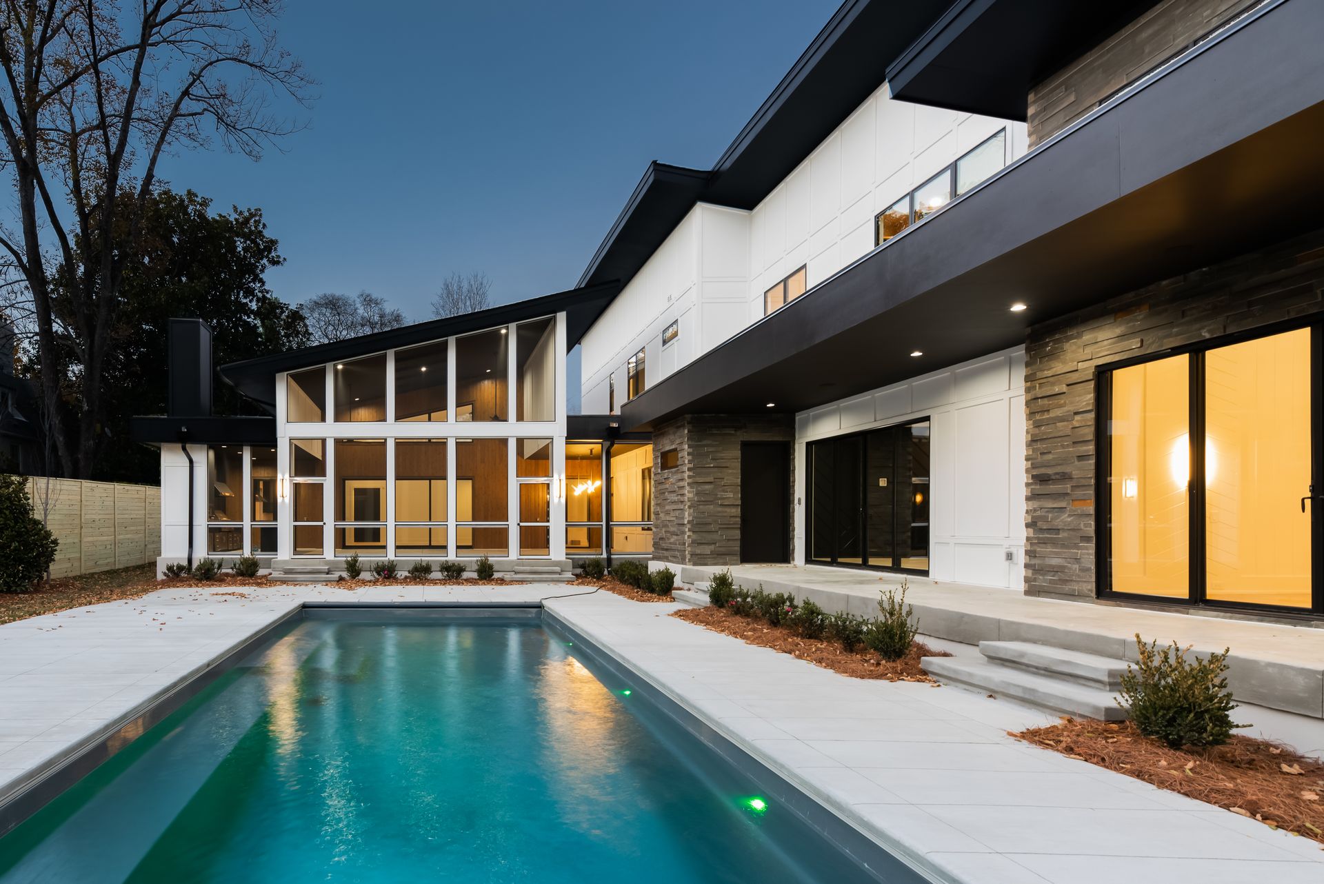 A large house with a large swimming pool in front of it.