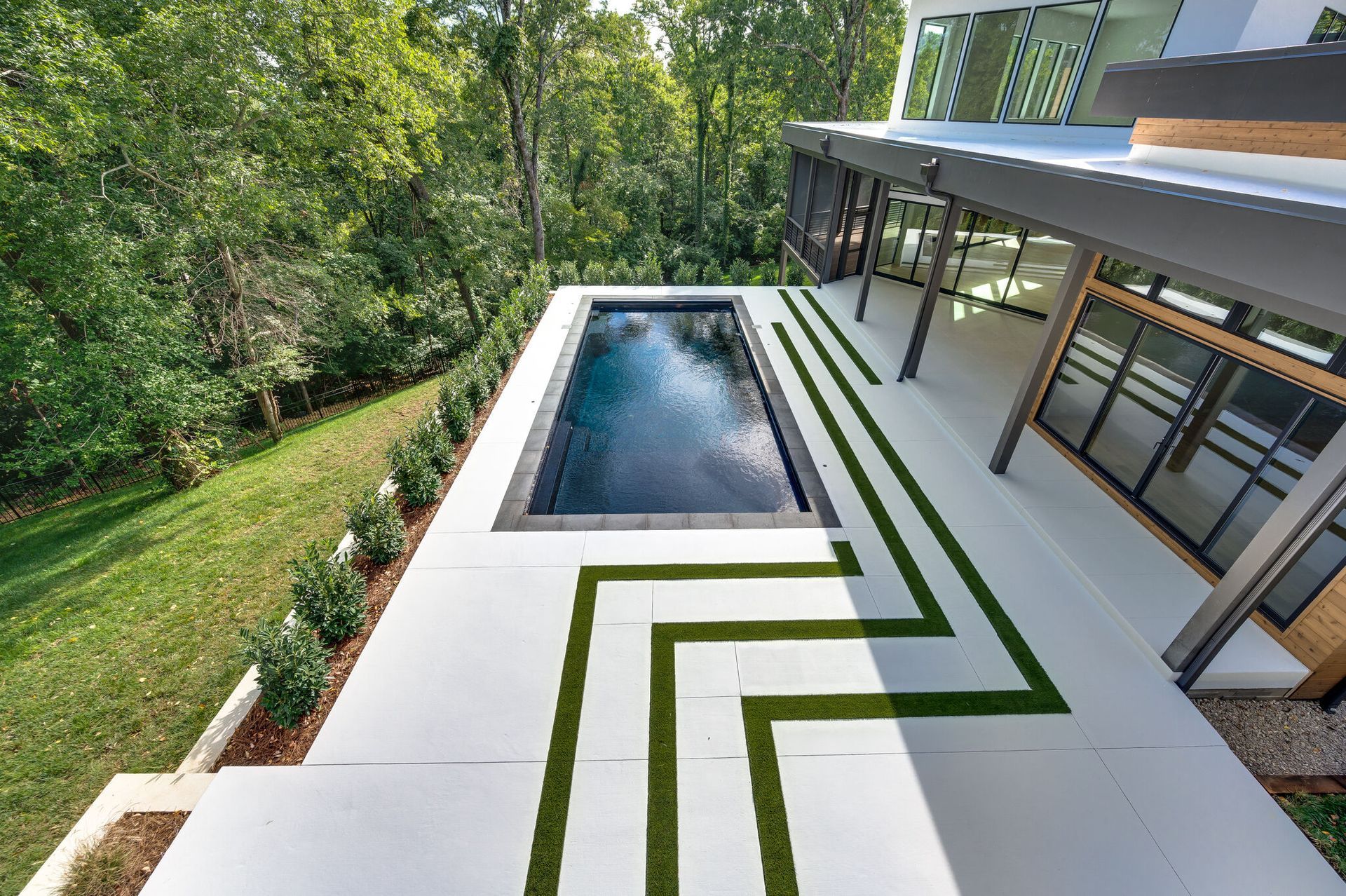 There is a large swimming pool in the backyard of a house.