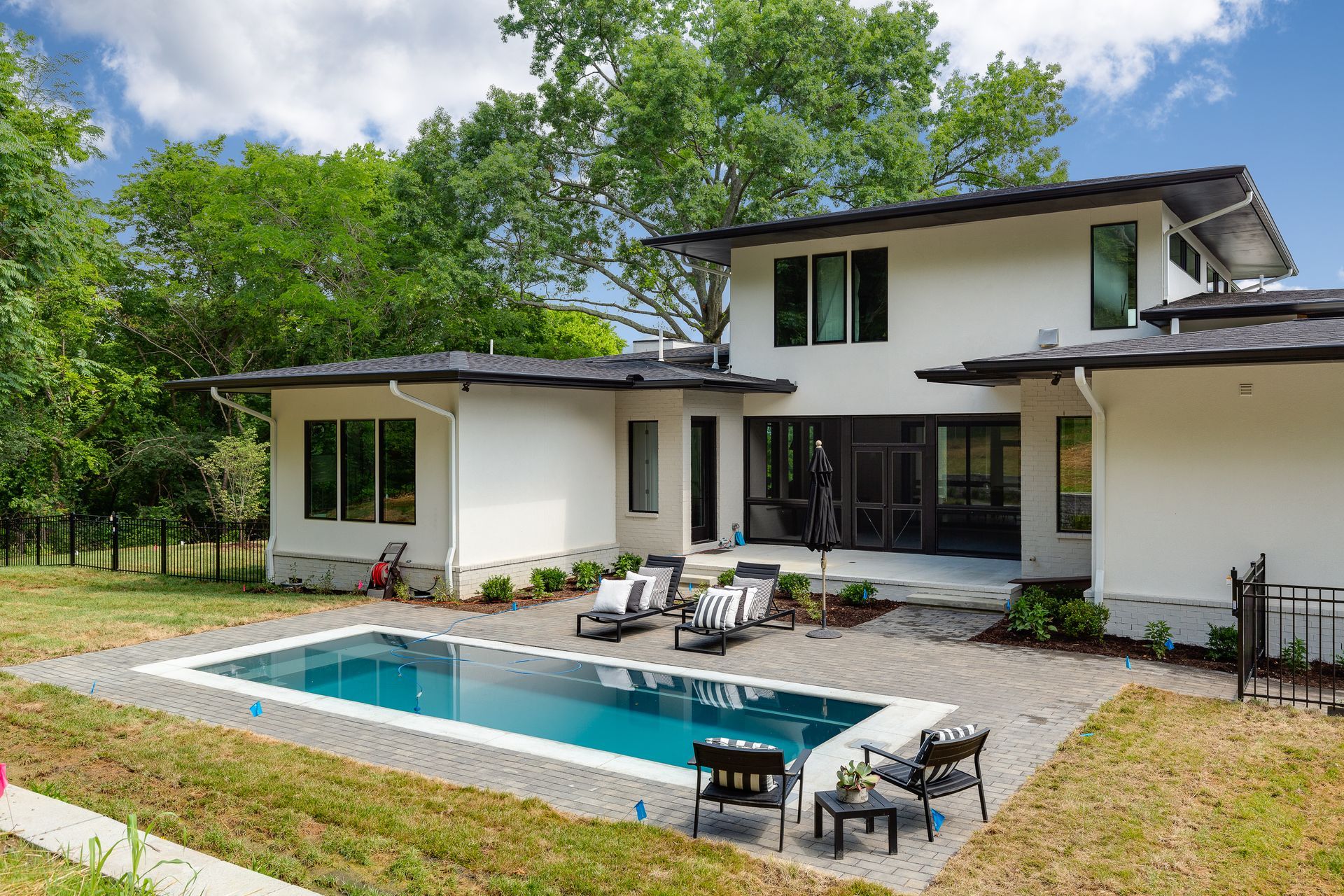 A large white house with a large swimming pool in the backyard.