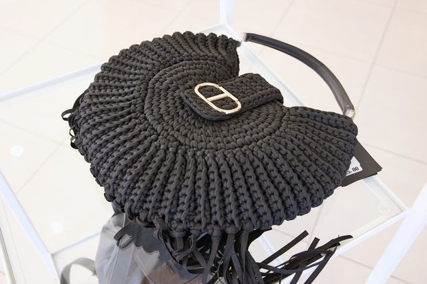 Una borsa nera all'uncinetto con una lettera b dorata sopra
