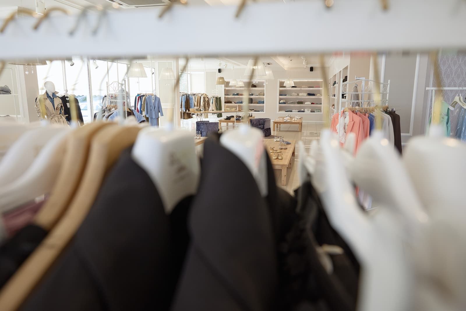 Un mucchio di vestiti sono appesi su uno scaffale in un negozio.