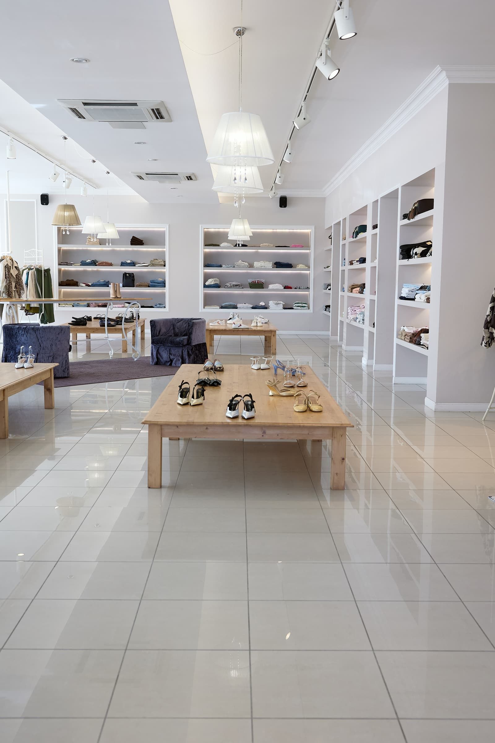 Un negozio di scarpe con tavoli e scaffali pieni di scarpe.