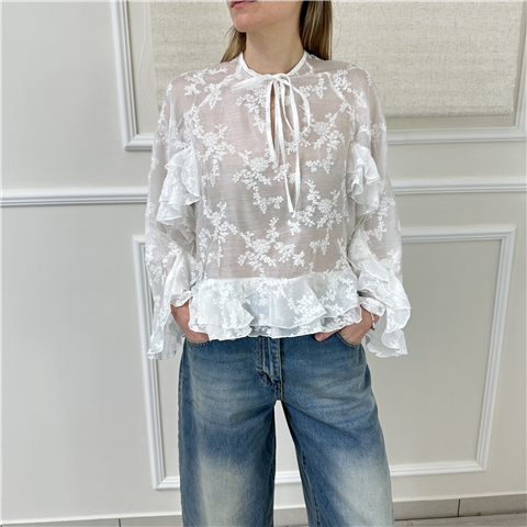 Una donna indossa un top azzurro e una gonna verde con paillettes.