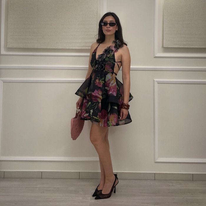 Una donna vestita di bianco è in piedi su un balcone.