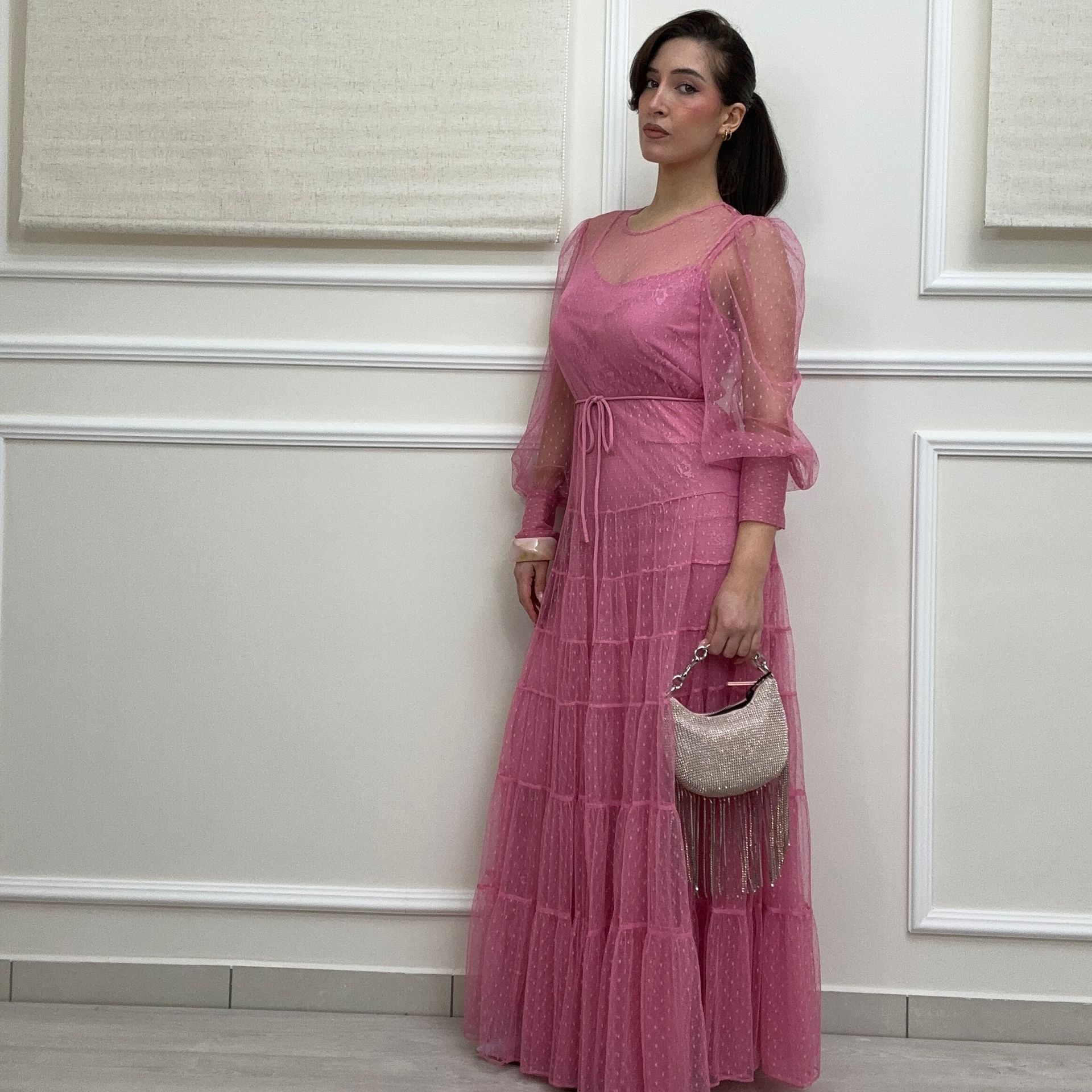 Una donna con un abito blu con paillettes è accovacciata su uno specchio.