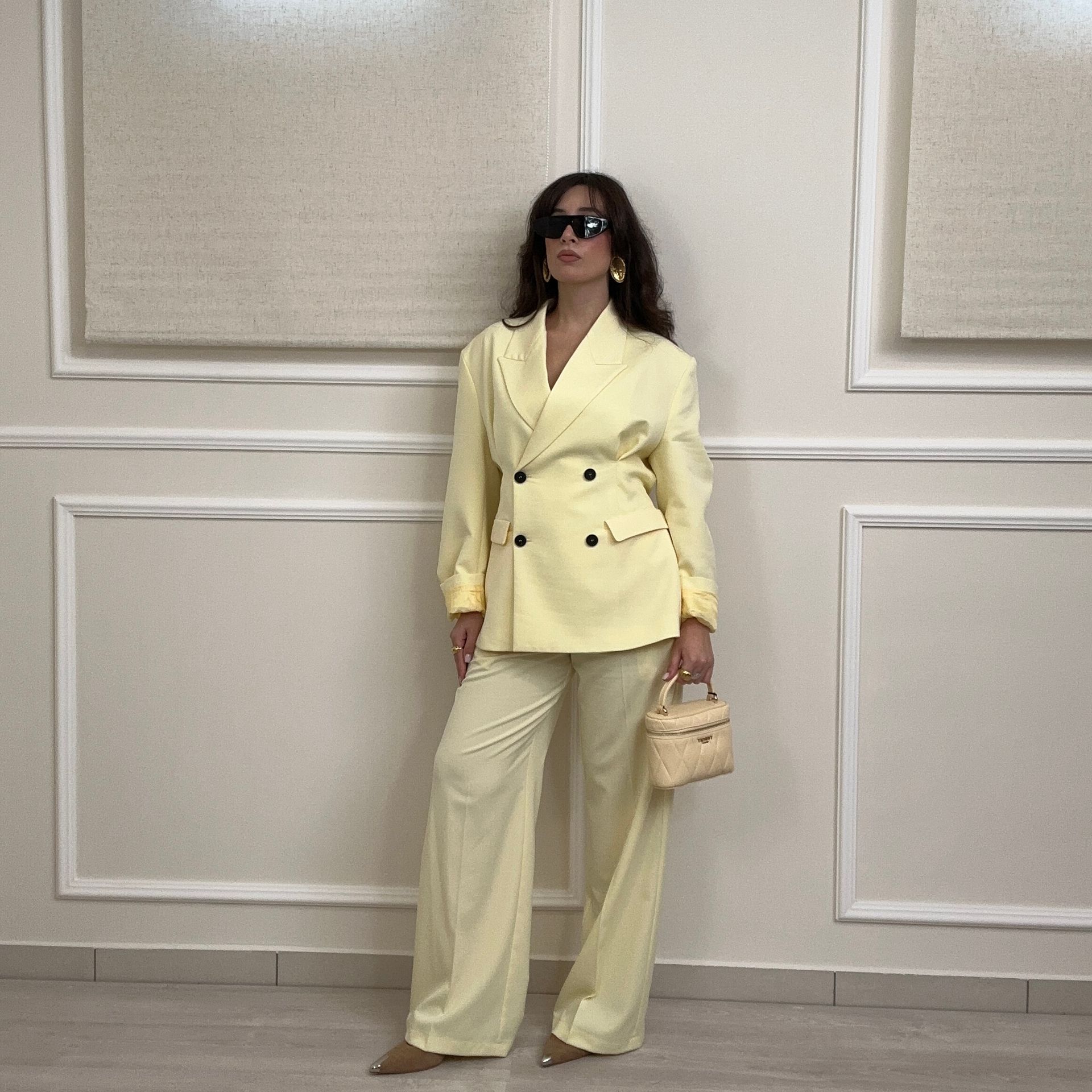 Una donna con un abito blu con paillettes è accovacciata su uno specchio.