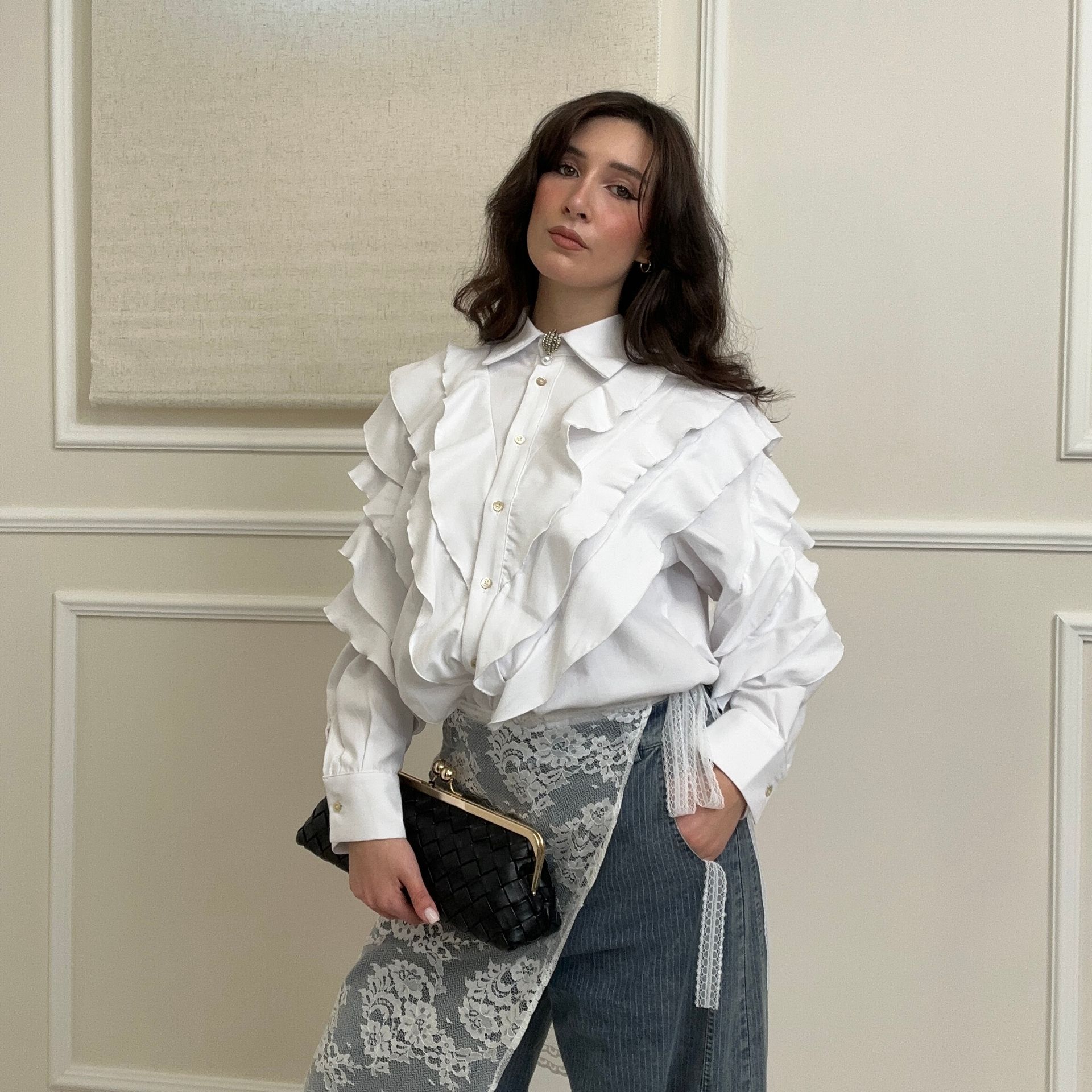 Una donna vestita di bianco è seduta su un muro.