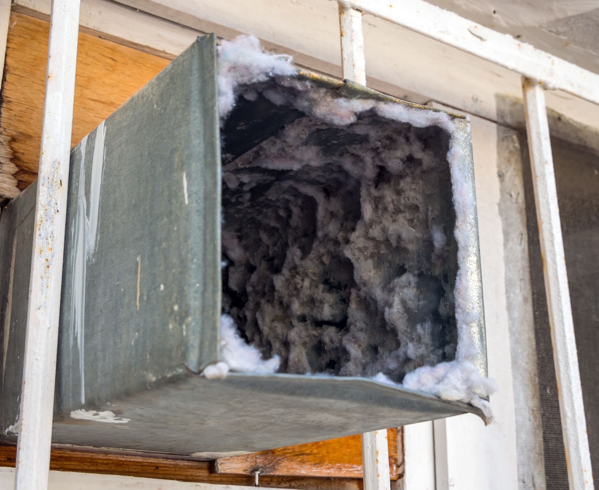 A dirty air duct with a lot of dust coming out of it.