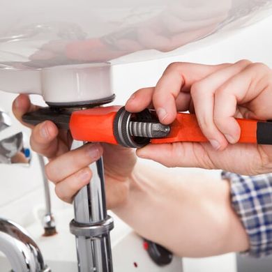 Plumber fixing a sink — Plumbing Services in Valparaiso, IN