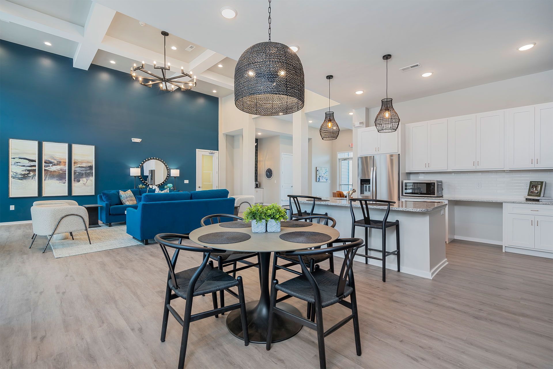 Open-concept community lounge with blue accent wall, seating, and a kitchen island.