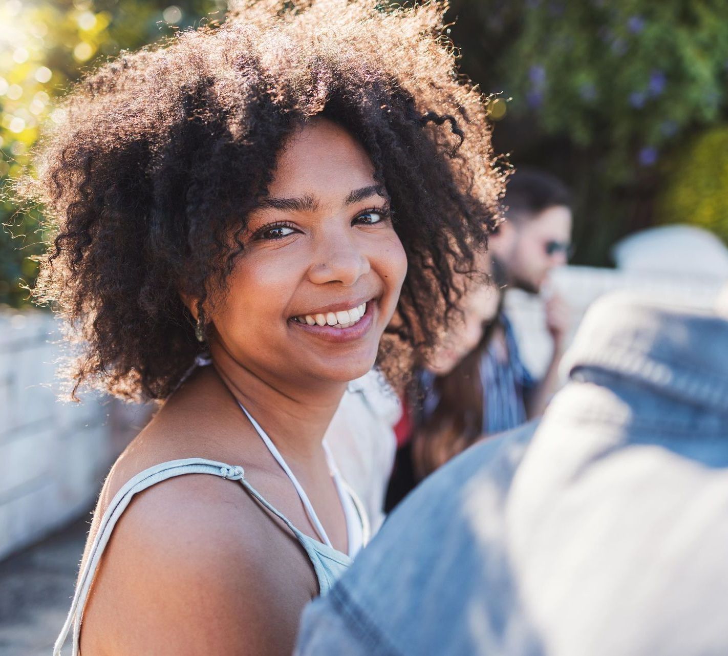 A woman with curly hair is smiling for the camera