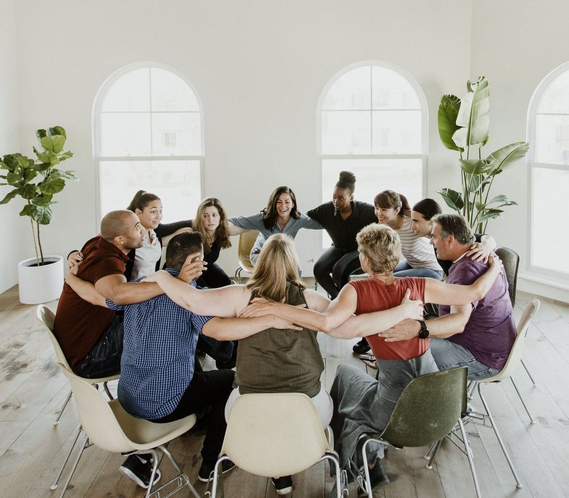 A group of people are standing in a line giving thumbs up.