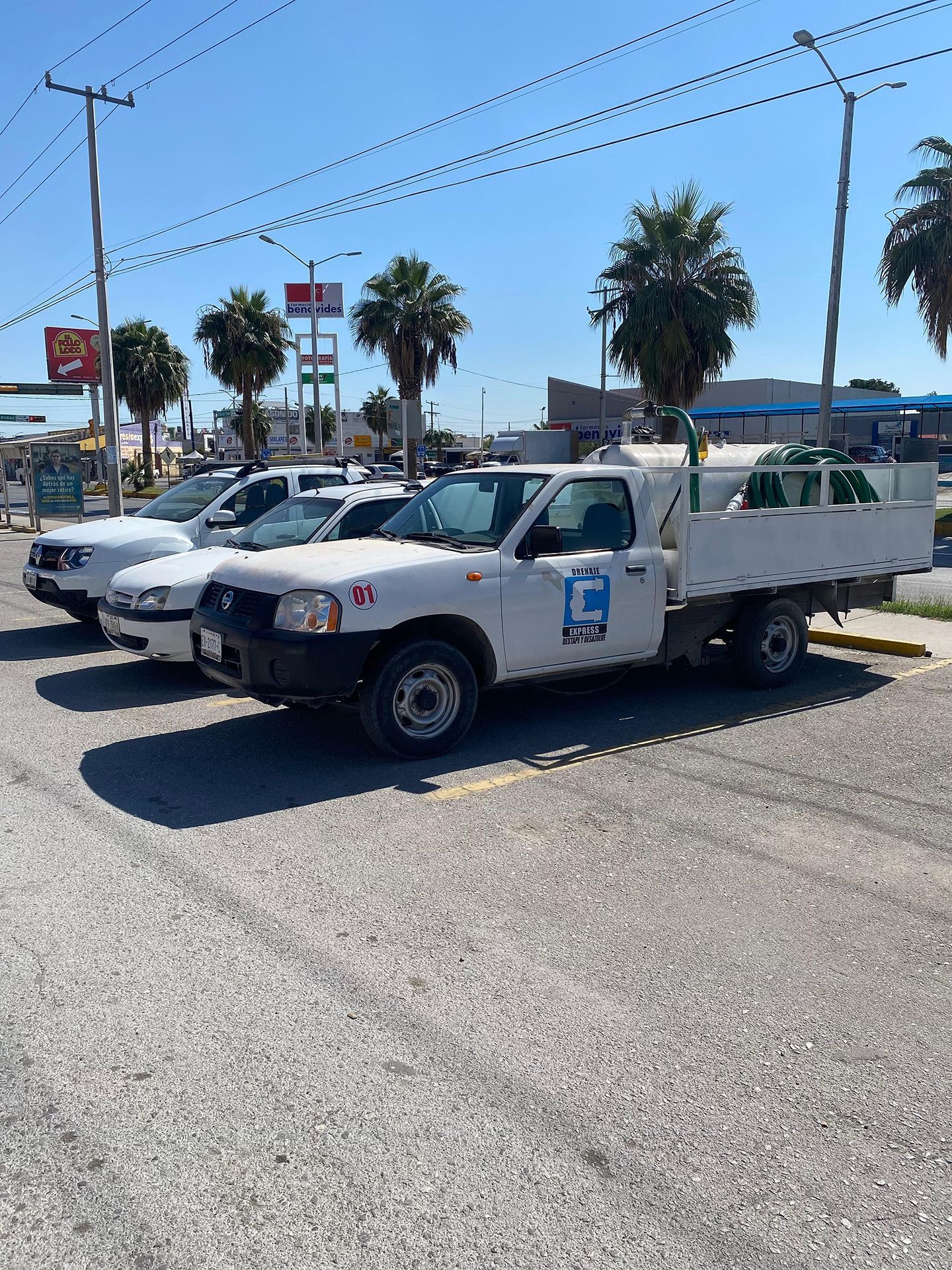 Una fila de camiones blancos están estacionados en un estacionamiento.
