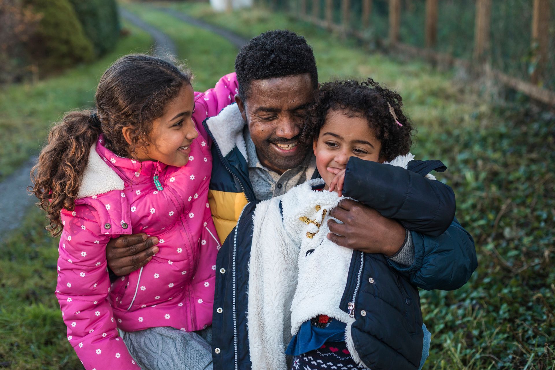 Two women are sitting at a table with laptops and talking to each other.