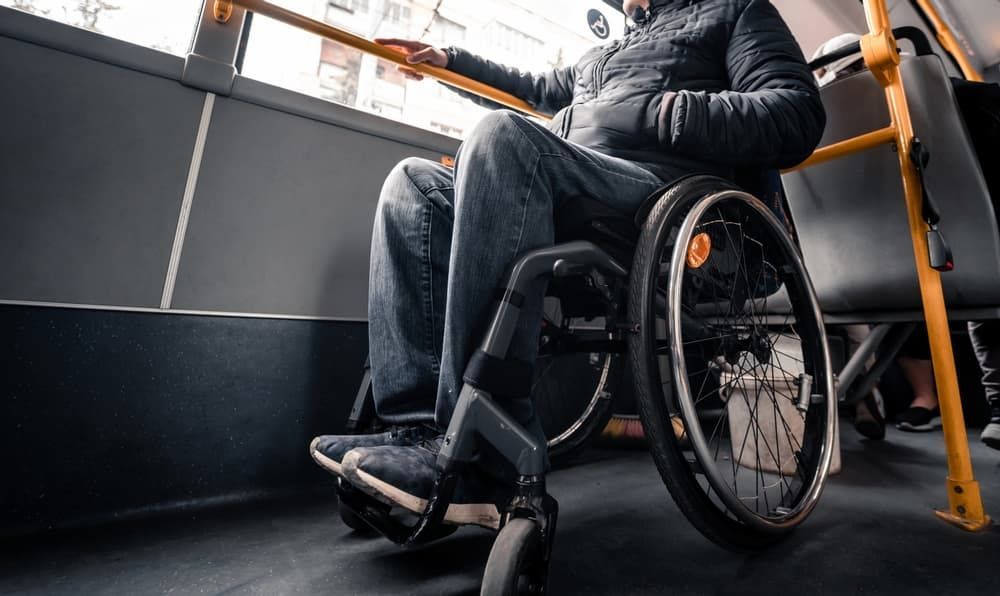 A Man in A Wheelchair Is Sitting on A Bus — Coast 2 Coast Disability Support Services in Taree, NSW